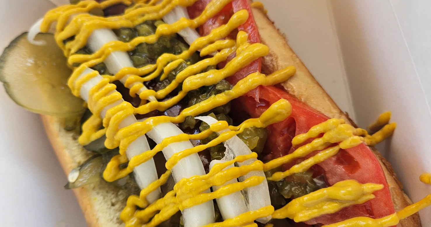 Chicago-style hot dog — all-beef dog with mustard, neon relish, sport peppers, tomato, pickle, and celery salt on a poppy seed bun