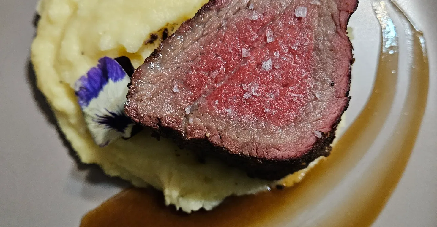 Sliced beef tenderloin over whipped potatoes by Chef B