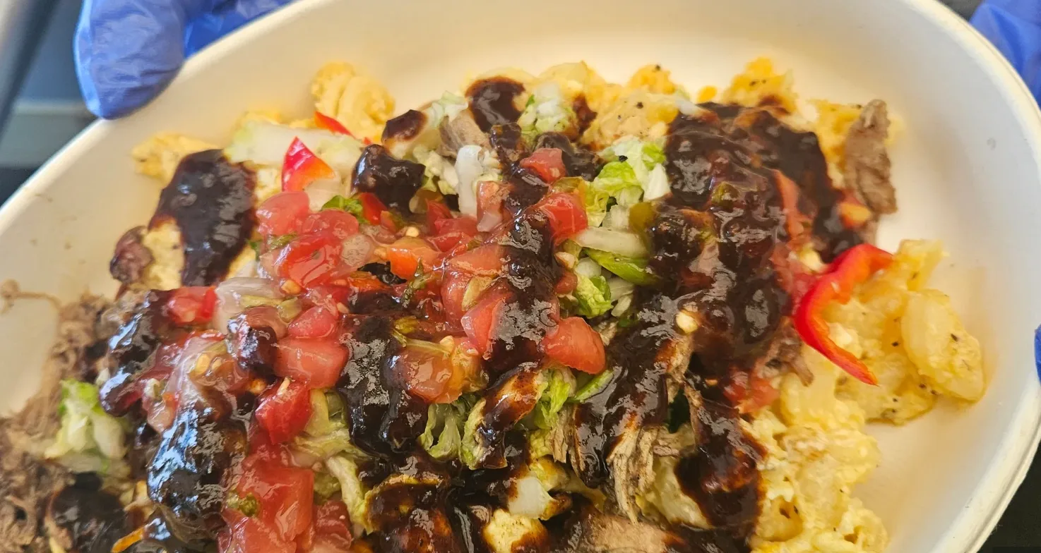 Jerk Pork Mac — Grandma's mac and cheese topped with slow-braised jerk pork, pico, and candied sauce drizzle