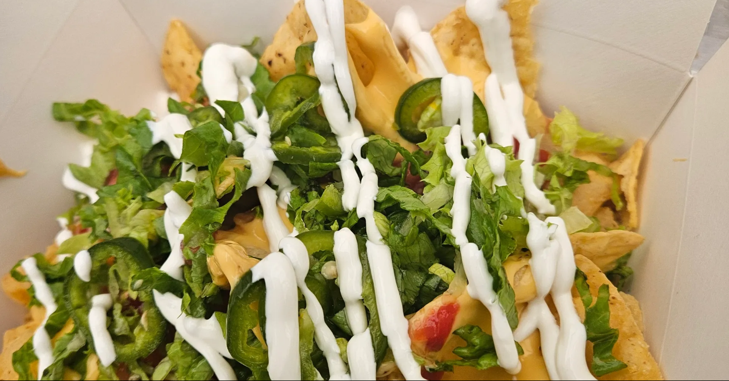 Loaded Nachos — house queso, pico, jalapeño, sour cream, and choice of protein