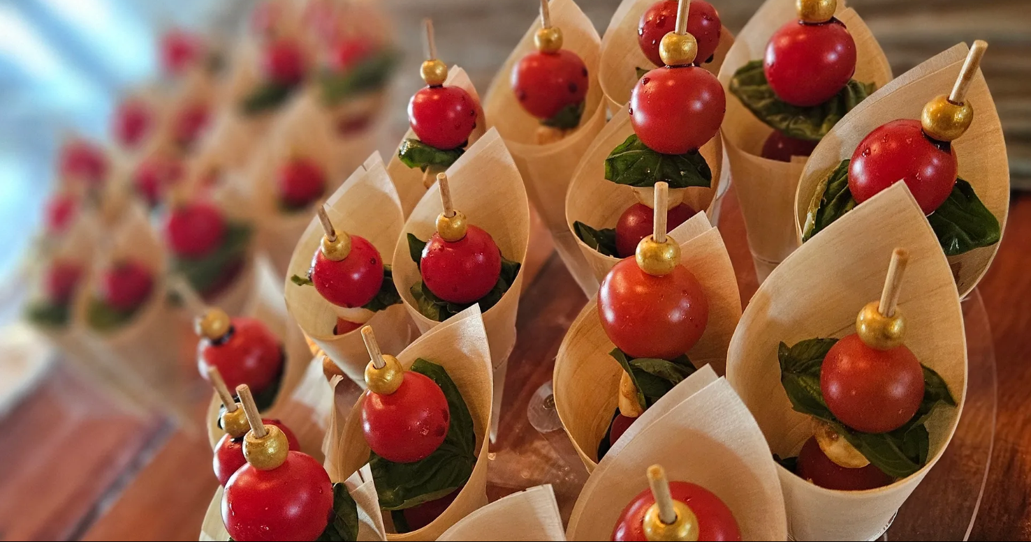 Caprese skewers — fresh mozzarella, cherry tomatoes, and basil arranged on wooden skewers