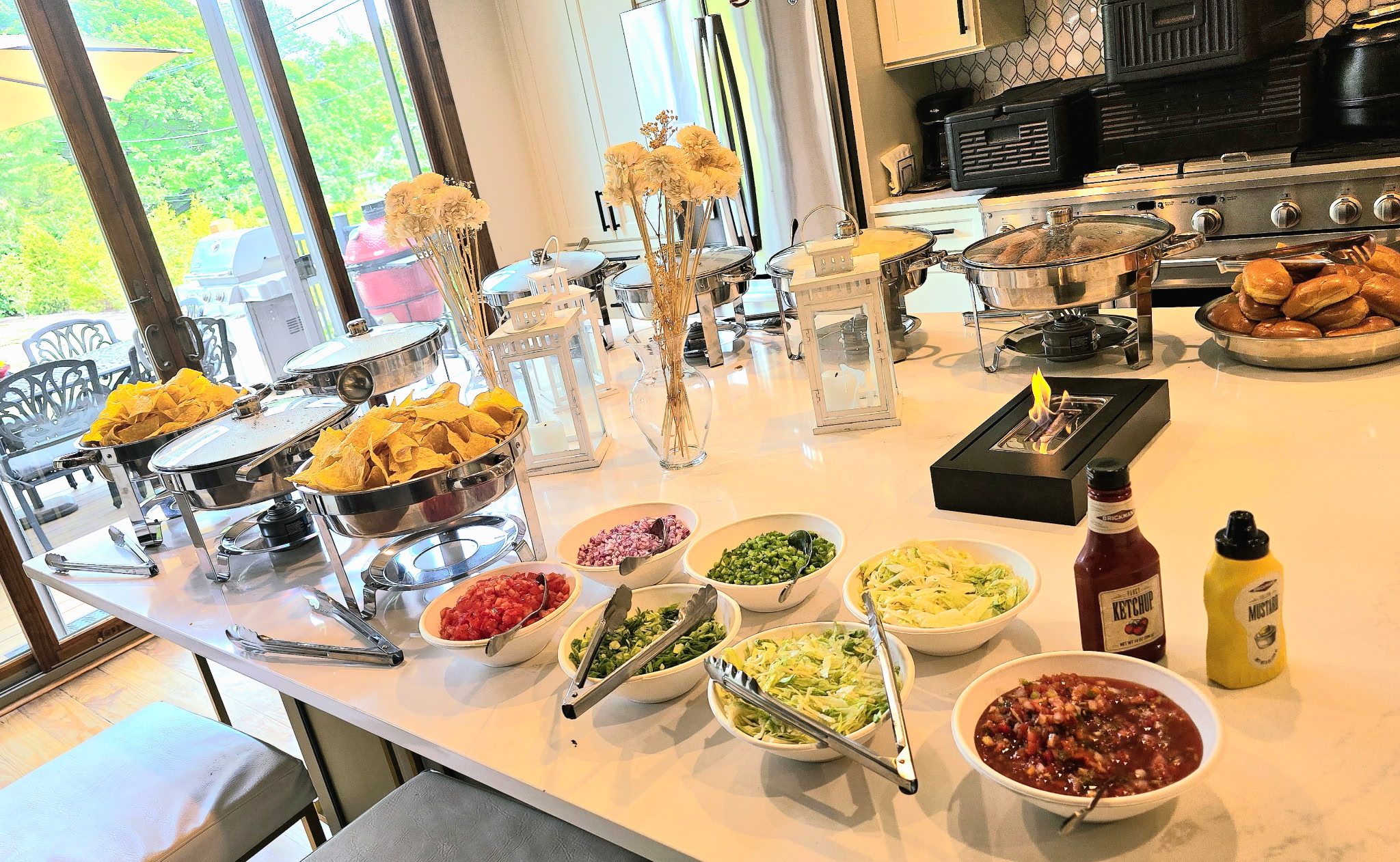 Nacho bar toppings station with pico de gallo, diced onion, jalapeño, and shredded lettuce alongside tortilla chips